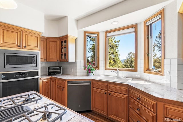 6252 King Dr, Evergreen, CO 80439 - kitchen with stainless steel appliances, a sink, brown cabinets, and glass insert cabinets