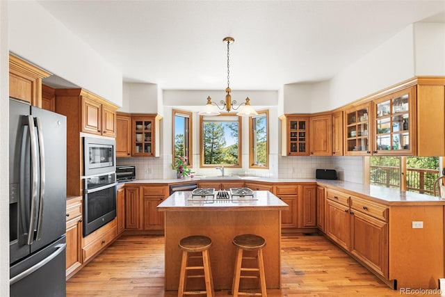 6252 King Dr, Evergreen, CO 80439 - kitchen featuring appliances with stainless steel finishes, plenty of natural light, a center island, and backsplash