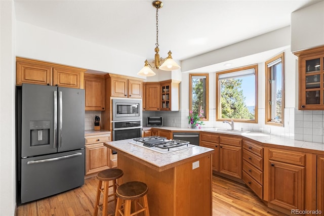 6252 King Dr, Evergreen, CO 80439 - kitchen featuring stainless steel appliances, light wood-style flooring, a sink, and glass insert cabinets