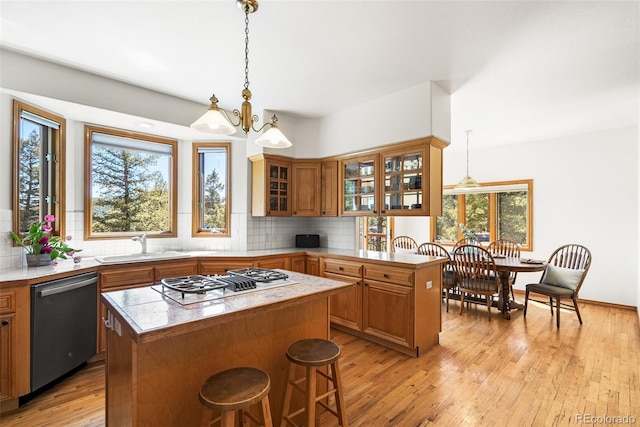 6252 King Dr, Evergreen, CO 80439 - kitchen with stainless steel dishwasher, gas cooktop, a kitchen island, a sink, and brown cabinets