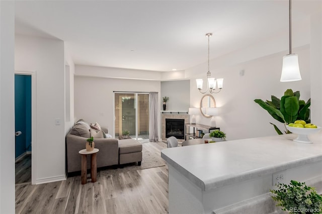 332 N Parkside Dr Unit C, Longmont, CO 80501 - living area with light wood-style floors, a fireplace, and a chandelier