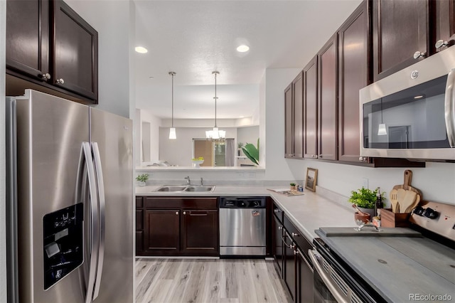 332 N Parkside Dr Unit C, Longmont, CO 80501 - kitchen with stainless steel appliances, a chandelier, light wood-type flooring, dark brown cabinetry, and light countertops