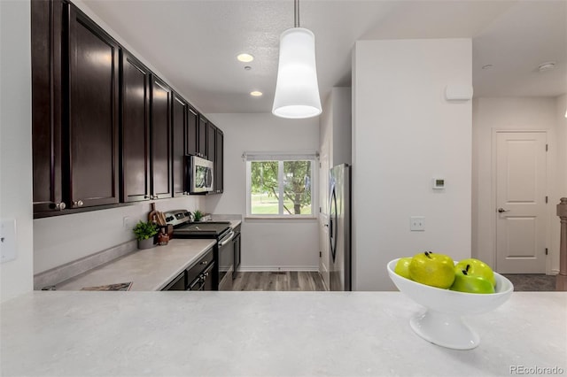 332 N Parkside Dr Unit C, Longmont, CO 80501 - kitchen with stainless steel appliances, light countertops, dark brown cabinets, recessed lighting, and pendant lighting