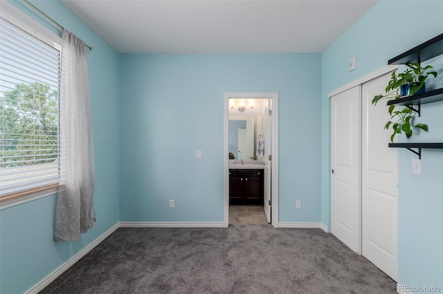 332 N Parkside Dr Unit C, Longmont, CO 80501 - unfurnished bedroom featuring multiple windows, carpet floors, a closet, and connected bathroom