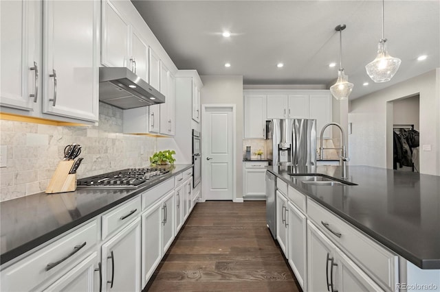 kitchen with white cabinetry, sink, hanging light fixtures, stainless steel appliances, and a center island with sink