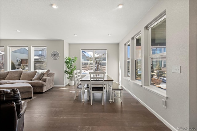 dining space featuring dark wood-type flooring and a textured ceiling