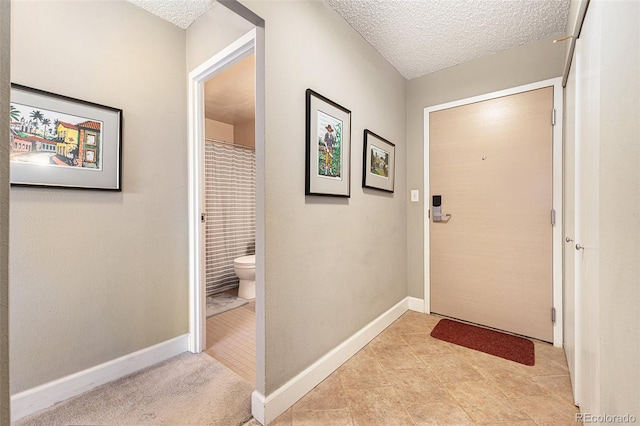 doorway featuring light tile patterned floors and a textured ceiling