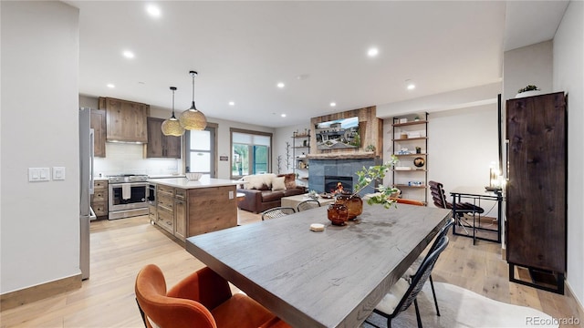 dining room with light hardwood / wood-style floors and a tile fireplace