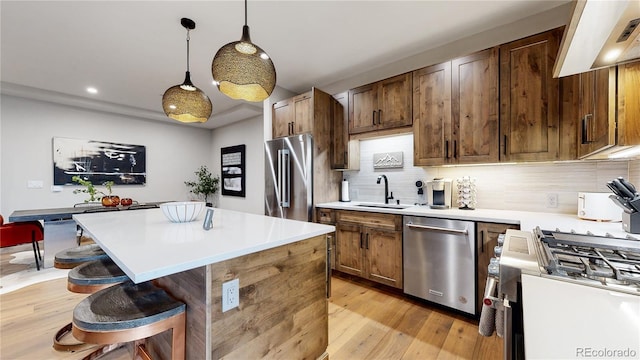 kitchen with sink, hanging light fixtures, decorative backsplash, appliances with stainless steel finishes, and custom exhaust hood