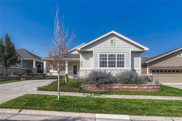 view of front of home featuring stone siding, driveway, and a garage