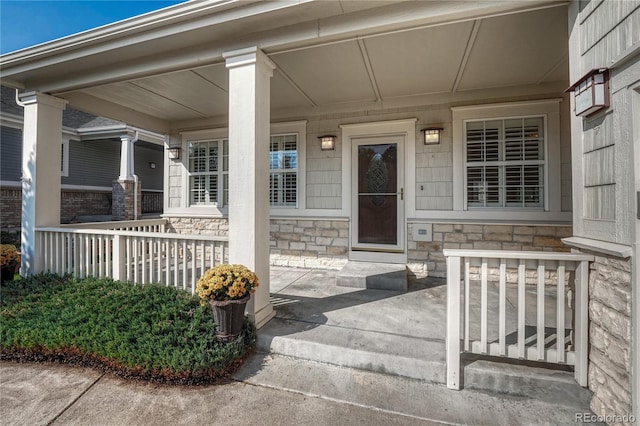 entrance to property featuring stone siding and a porch