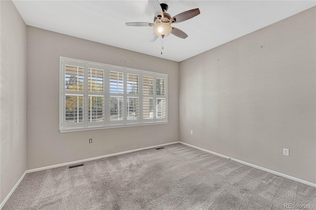 carpeted empty room featuring visible vents, baseboards, and ceiling fan