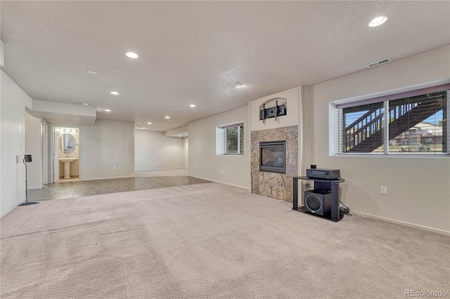 unfurnished living room with recessed lighting, baseboards, carpet, and a high end fireplace