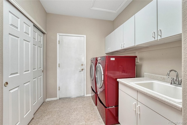 laundry area with cabinet space, washing machine and dryer, baseboards, and a sink