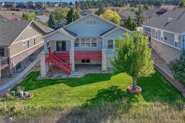 back of house with stairs, a deck, a lawn, and a residential view