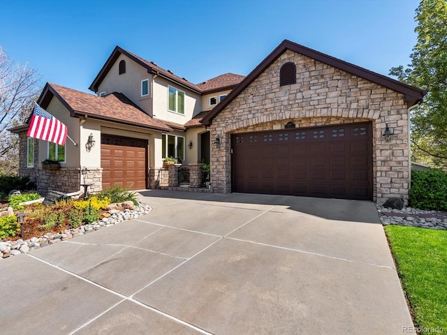 6266 W Prentice Ave, Littleton, CO 80123 - view of front facade featuring concrete driveway, a garage, stucco siding, and stone siding