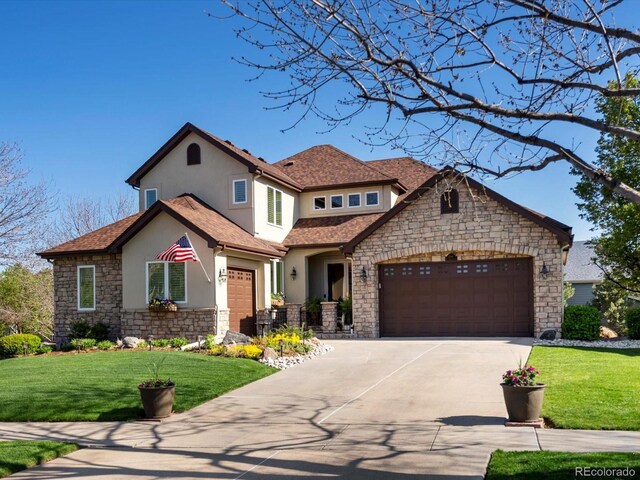 6266 W Prentice Ave, Littleton, CO 80123 - view of front of home featuring stone siding, a garage, stucco siding, a front yard, and driveway