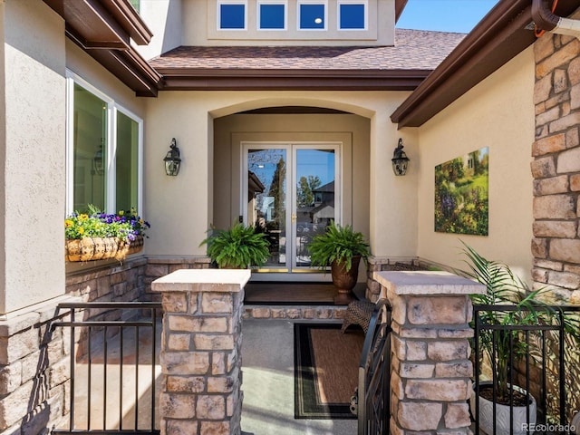 6266 W Prentice Ave, Littleton, CO 80123 - property entrance featuring stone siding, french doors, stucco siding, and roof with shingles