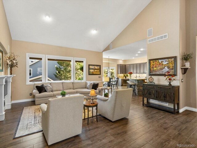 6266 W Prentice Ave, Littleton, CO 80123 - living area featuring baseboards, dark wood-type flooring, visible vents, and high vaulted ceiling