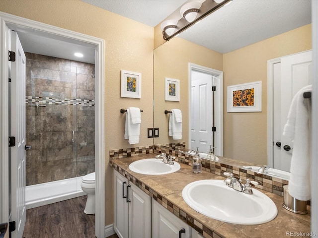6266 W Prentice Ave, Littleton, CO 80123 - bathroom featuring a sink, double vanity, toilet, and a tile shower