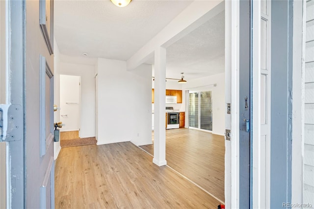 foyer entrance with a textured ceiling and light hardwood / wood-style flooring