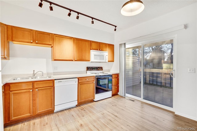 kitchen with white appliances, track lighting, light hardwood / wood-style flooring, and sink