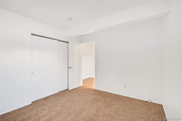 unfurnished bedroom with carpet flooring and a closet