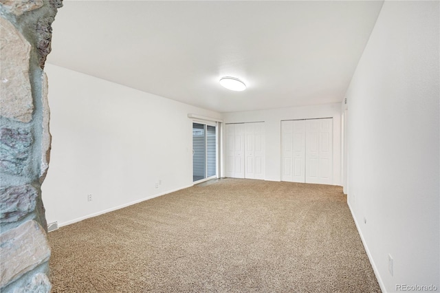 unfurnished bedroom with carpet and two closets