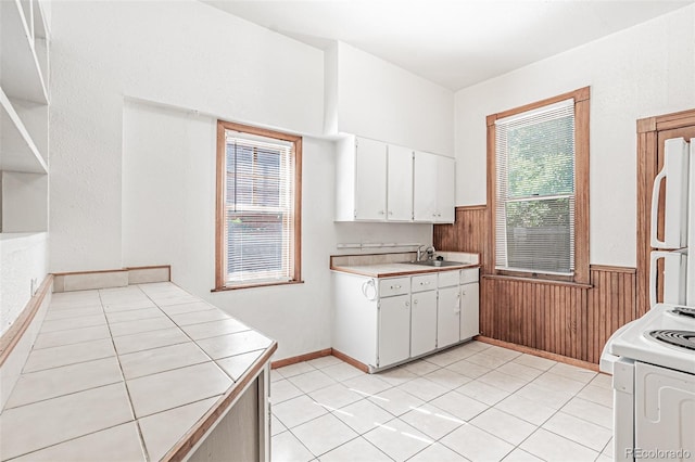 873 S Logan St, Denver, CO 80209 - kitchen with white appliances, wainscoting, white cabinets, wooden walls, and light tile patterned floors