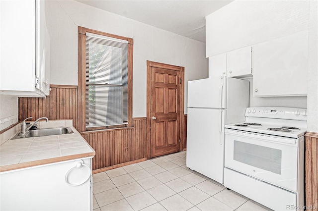 873 S Logan St, Denver, CO 80209 - kitchen featuring white appliances, wainscoting, tile counters, wooden walls, and white cabinetry
