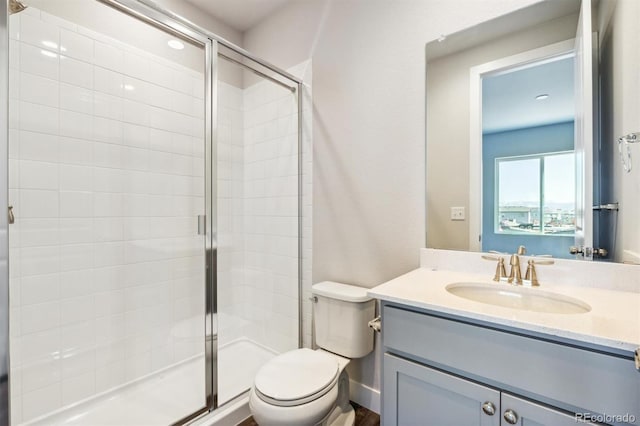 bathroom featuring vanity, toilet, and a shower with door