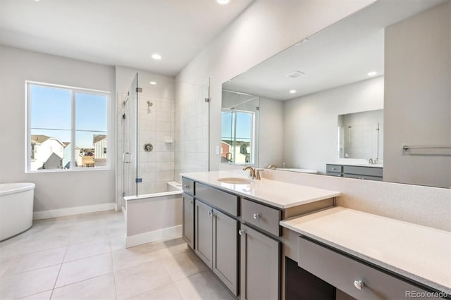 bathroom featuring tile patterned flooring, vanity, a shower with shower door, and a wealth of natural light