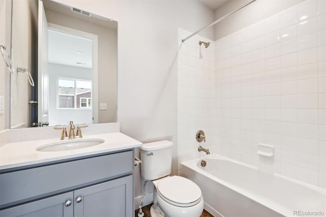 full bathroom with vanity, tiled shower / bath combo, and toilet