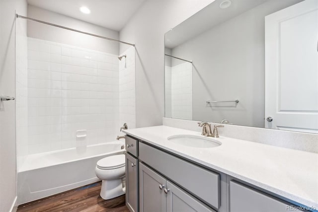 full bathroom with shower / tub combination, vanity, hardwood / wood-style flooring, and toilet