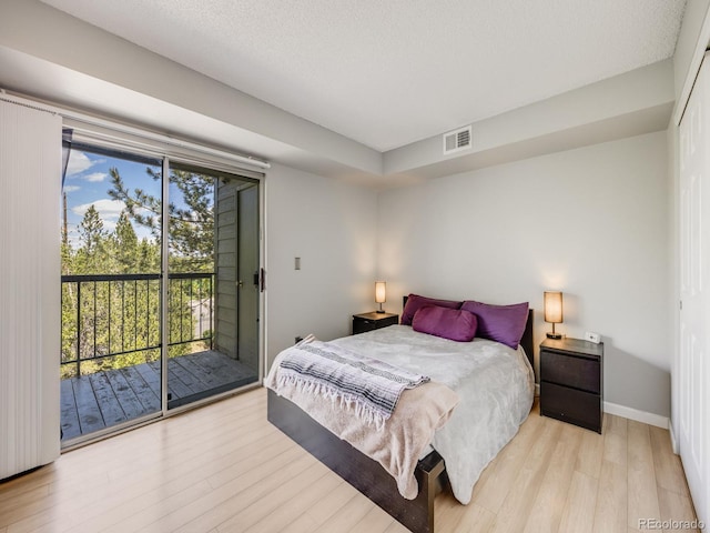 2575 S Syracuse Way Unit K201, Denver, CO 80231 - bedroom featuring access to exterior, light wood-style floors, and baseboards