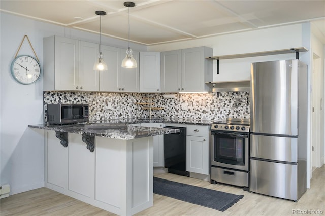 kitchen with a peninsula, light wood-style floors, appliances with stainless steel finishes, and dark stone counters