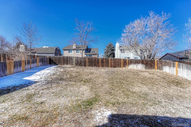 yard layered in snow with a fenced backyard