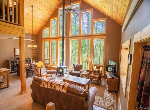 25879 County Road 162e, Nathrop, CO 81236 - living area featuring a wood stove, high vaulted ceiling, ceiling fan, a chandelier, and light tile patterned flooring