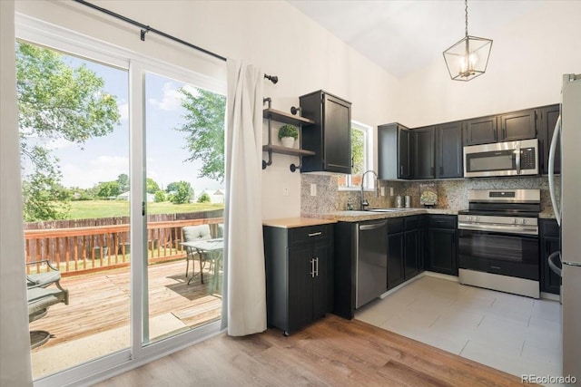6318 Newton Ct, Arvada, CO 80003 - kitchen with appliances with stainless steel finishes, tasteful backsplash, light countertops, open shelves, and high vaulted ceiling