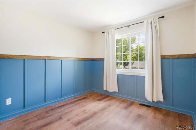 6318 Newton Ct, Arvada, CO 80003 - spare room featuring a decorative wall, wood finished floors, and a wainscoted wall