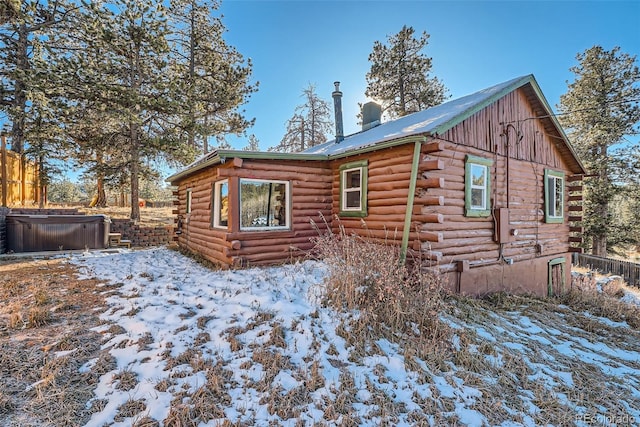 34502 Chilton Ave, Pine, CO 80470 - snow covered rear of property with a hot tub, fence, and log exterior