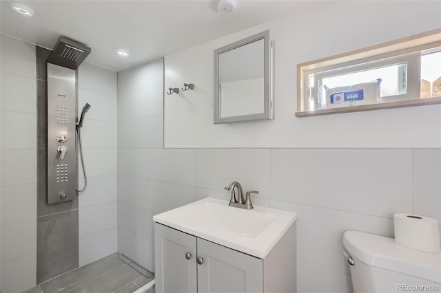 34502 Chilton Ave, Pine, CO 80470 - full bathroom with tile walls, a tile shower, vanity, and toilet