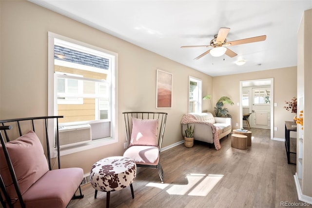 interior space featuring connected bathroom, multiple windows, hardwood / wood-style floors, and ceiling fan