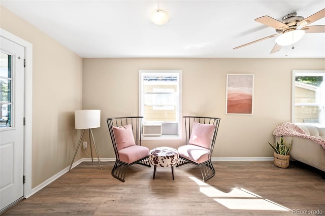 living area featuring wood-type flooring and ceiling fan