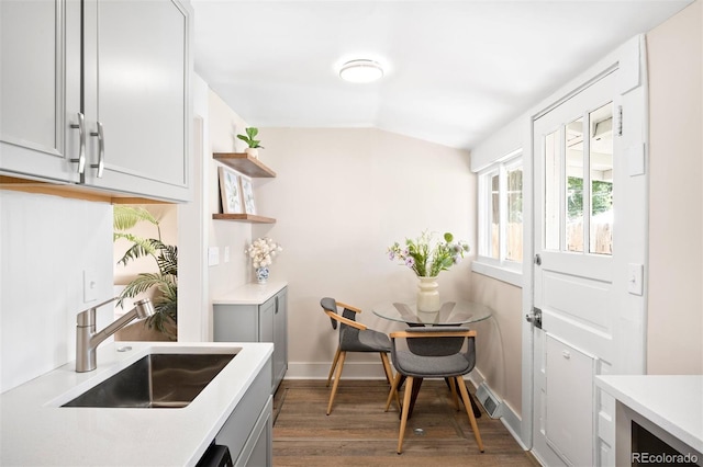 kitchen featuring vaulted ceiling, gray cabinets, dark hardwood / wood-style floors, and sink