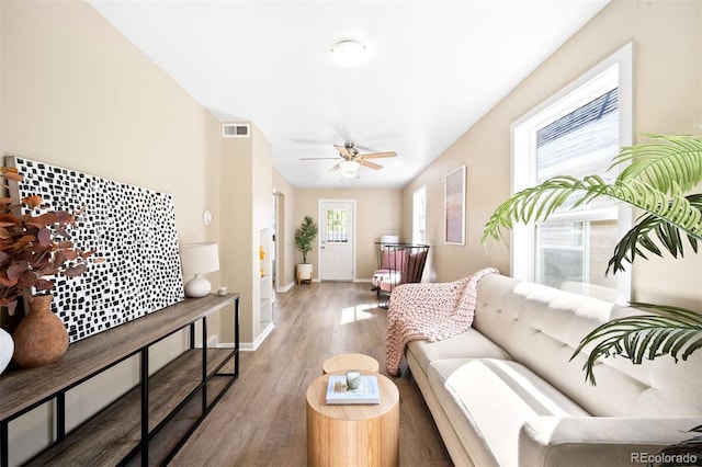 living room featuring ceiling fan, hardwood / wood-style floors, and a wealth of natural light