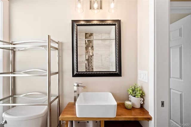 bathroom featuring toilet, sink, and an enclosed shower