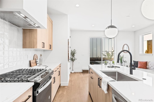 kitchen featuring pendant lighting, appliances with stainless steel finishes, wall chimney exhaust hood, decorative backsplash, and light brown cabinetry