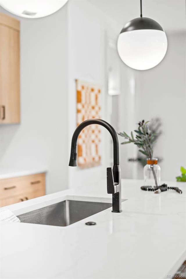 details with pendant lighting, sink, and light brown cabinets