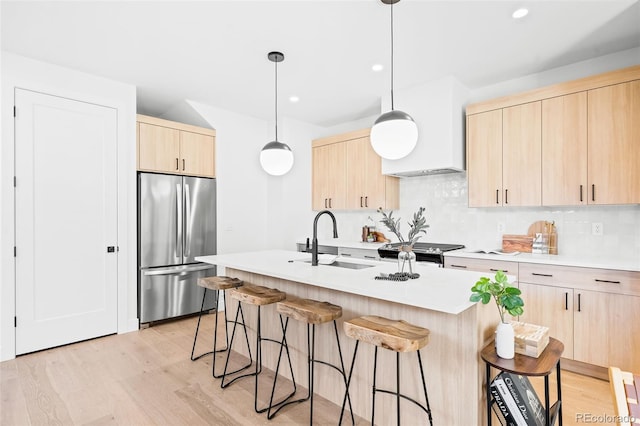 kitchen with tasteful backsplash, stainless steel appliances, light brown cabinets, and hanging light fixtures